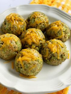 broccoli cheese balls on a white plate with a yellow towel in the background