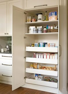 an open pantry door in a kitchen with lots of food on the shelves and cupboards