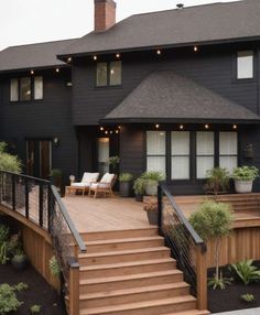 a large house with stairs leading up to the front door and deck area on top of it