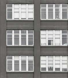 an apartment building with multiple windows and no doors on the front, in black and white