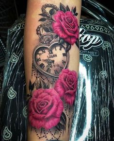 a woman's arm with pink roses and an old pocket watch tattoo on it