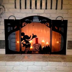 a fireplace with candles and mickey mouse on it