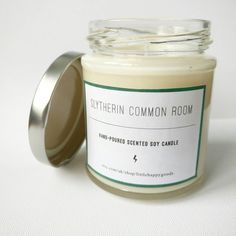 a candle that is sitting next to a white tablecloth with a label on it