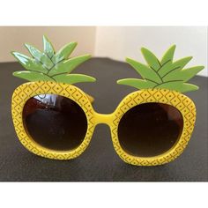 a pair of yellow sunglasses with pineapples on them