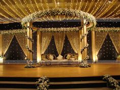 the stage is decorated with white flowers and greenery for a wedding or special event