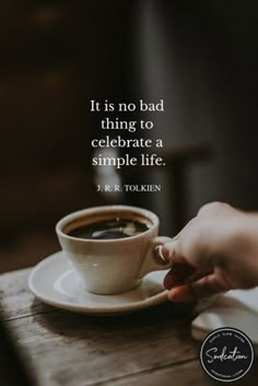 someone is holding their hand over a cup of coffee on a saucer with the quote it is no bad thing to celebrate a simple life