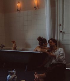 a man and woman sitting in a bathtub next to each other