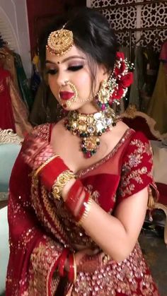 a woman in a red and gold bridal outfit