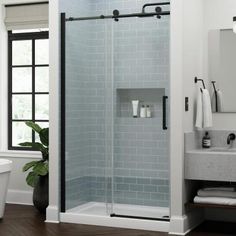 a bathroom with a glass shower door next to a sink