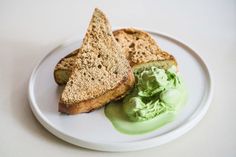 two pieces of bread on a plate with green sauce