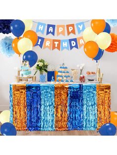 an image of a birthday party setting with balloons and streamers on the table in blue, orange and white colors