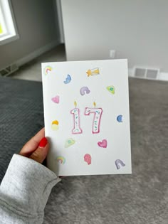 someone holding up a card with the number 17 on it