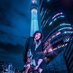 the woman is posing in front of the tall tower