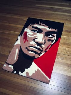 a rug with an image of a man's face painted on the floor in red, white and black