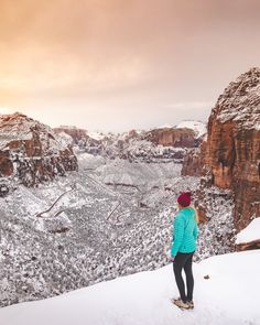 a woman standing on top of a snow covered mountain