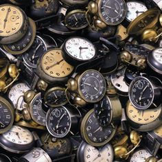 many different types of clocks are stacked on top of each other in this pile together