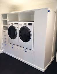 a white washer and dryer in a room with black carpeted flooring