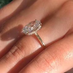 a close up of a person's hand with a diamond ring on their finger