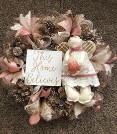 a wreath with an angel holding a sign that says, this home belongs