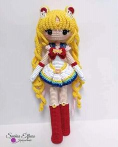 a crocheted doll with long blonde hair wearing a white dress and red boots