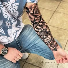 a man with a tattoo on his arm is sitting in front of a tile floor