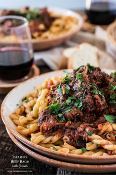 pasta with meat sauce and parsley in a bowl on a table next to bread