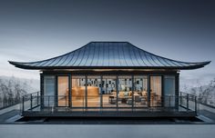 a house that is sitting on top of a roof with glass doors and windows in front of it