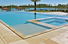 an empty swimming pool surrounded by trees and water