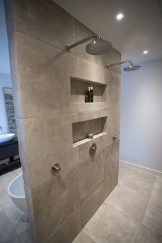 a bathroom with a shower head and shelves on the wall