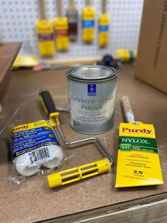 some paint and tools are sitting on a counter top next to a can of primer