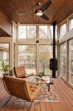 a living room filled with furniture and a fire place in the middle of a wooden floor