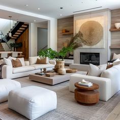 a living room filled with white furniture and a fire place in the middle of it