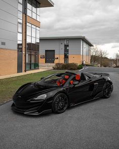 a black sports car parked in front of a building