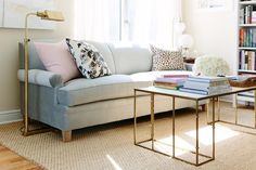 a living room with a couch, coffee table and bookshelf in the corner