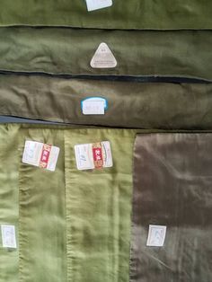 four different colored sheets with tags on them sitting next to each other in a pile