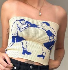 a woman wearing a blue and white knitted top with an elephant motif on it