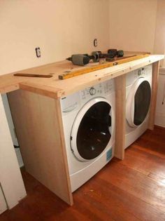 a washer and dryer in a room with wood flooring on the side