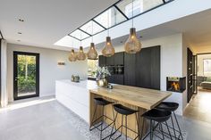 an open kitchen and dining area with modern lighting