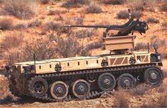 an army vehicle in the desert with a machine mounted on it's back end