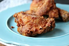 two fried chicken pieces on a blue plate