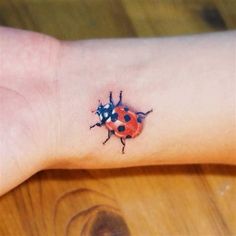 a ladybug tattoo on the left wrist