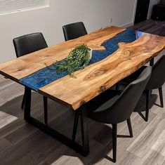 a wooden table with black chairs and a blue design on the top that is made out of wood