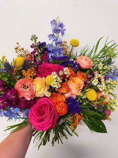 a bouquet of colorful flowers in someone's hand