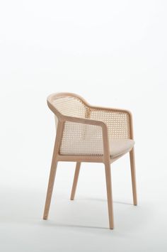 a chair made out of wood and wicker with a white back rest on the side