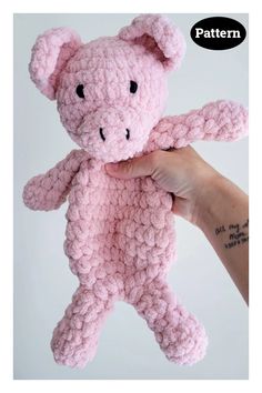 a hand holding a pink crocheted teddy bear