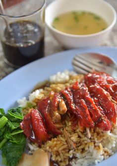 a white plate topped with rice and meat covered in sauce