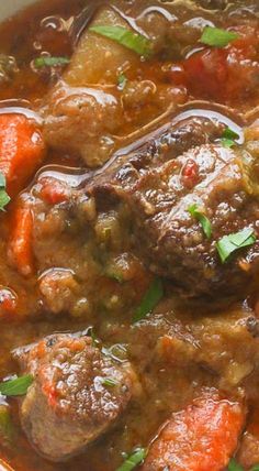 a bowl filled with meat and carrots on top of a table