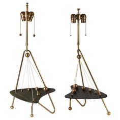 two brass and black sculptures with bells on each side, one is upside down while the other is upside down