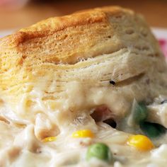 a close up of a plate of food with chicken pot pie on it's side