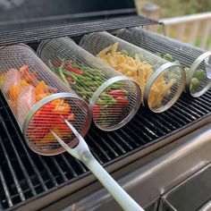 three baskets filled with different types of vegetables on top of a grill